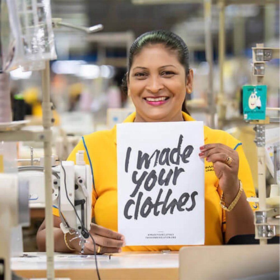 Woman holding a sign saying "I made your clothes"